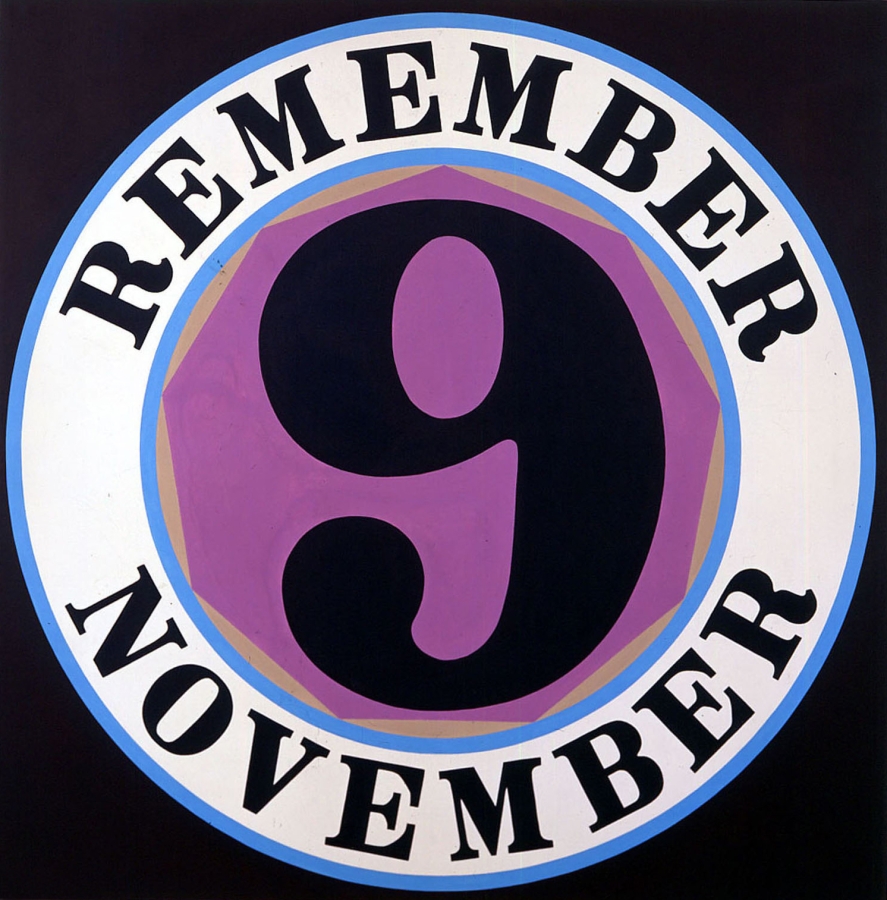 A 60 inch square canvas with a black ground dominated by a circle containing a purple nonagon with a black numeral nine surrounded by a white ring with blue outlines. Within the ring the painting's title, "Remember November," is painted in black letters.